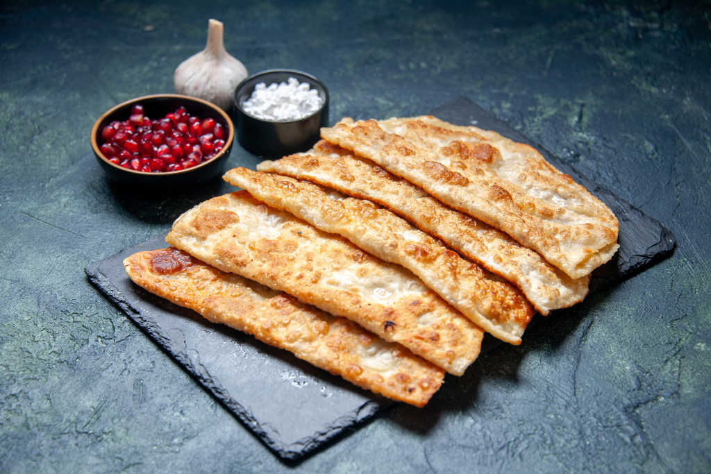 Simbolizando como abrir uma pastelaria: Pastéis fritos, sal, uma cabeça de alho e temperos.